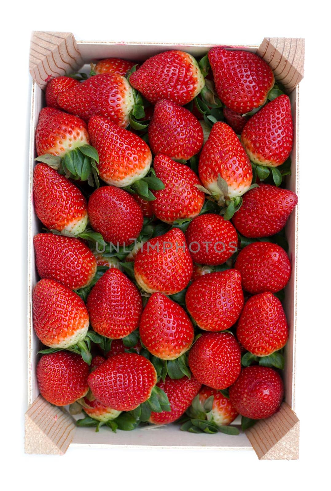 Strawberries in a wooden box. View from above. Isolate on white.