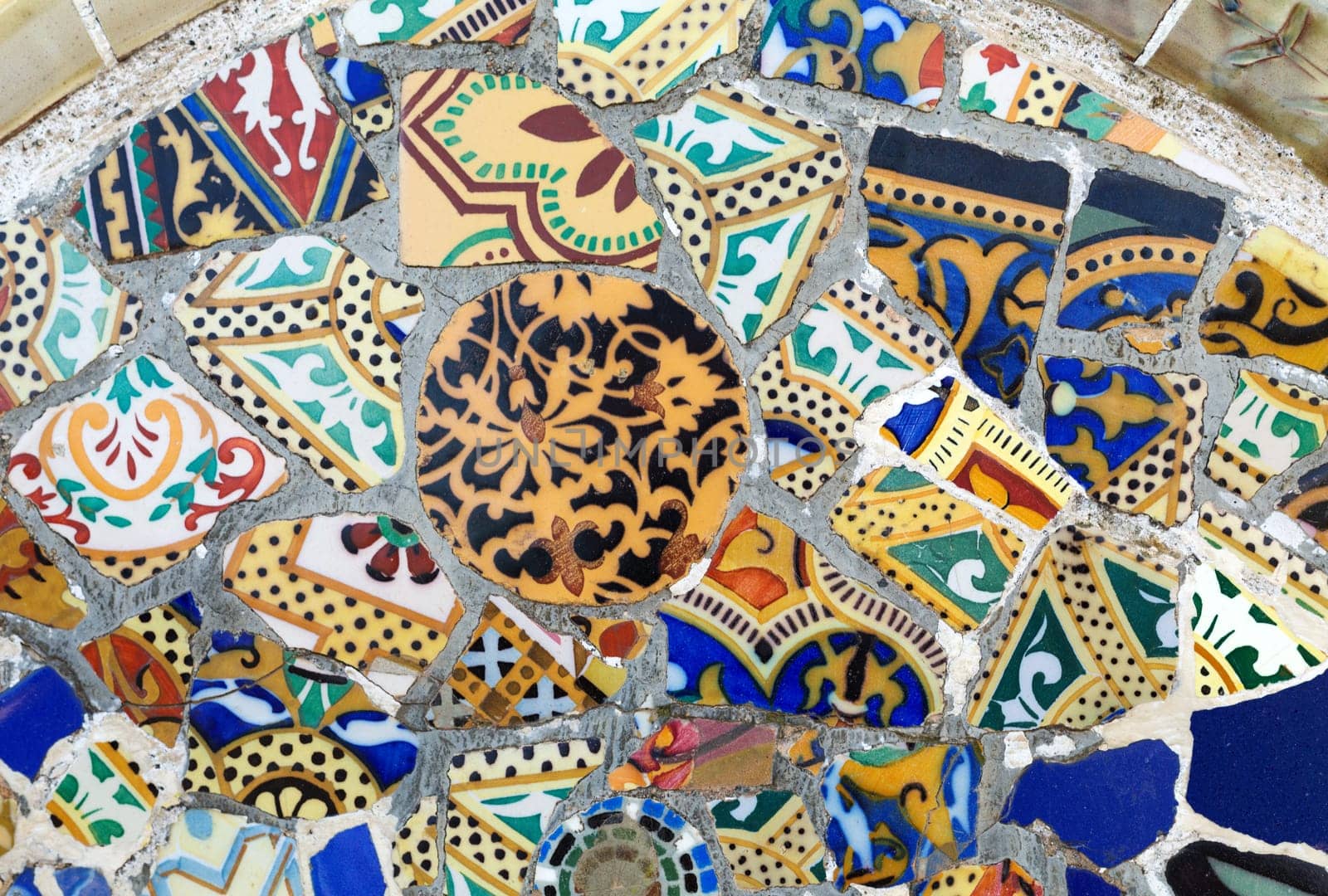Close-up of the ceramics in Park Guell Barcelona created by Gaudi. Detail of a mosaic on the wall.