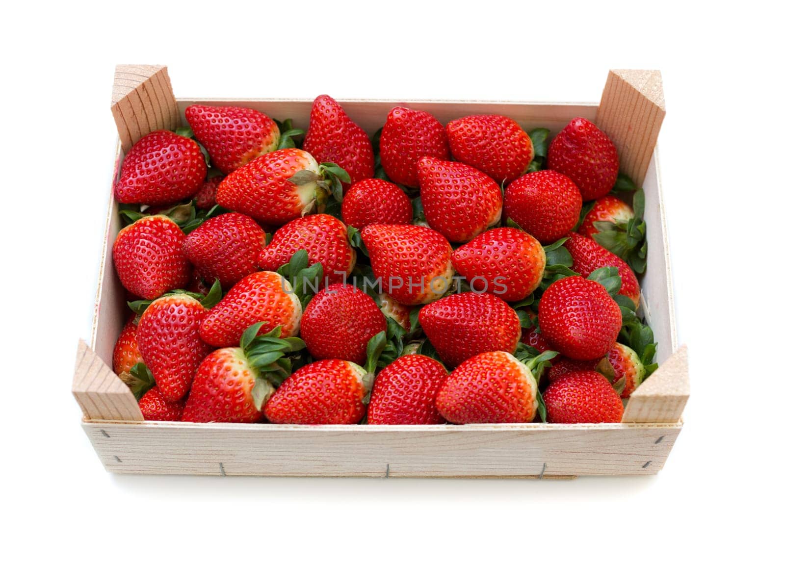 Fresh, fragrant, ripe strawberries in a wooden box on a white background.