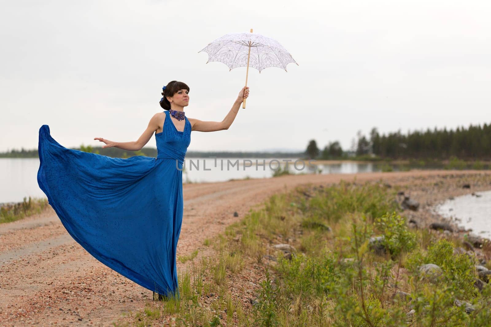 girl tries to keep a umbrella which pulls out a wind from her hands.