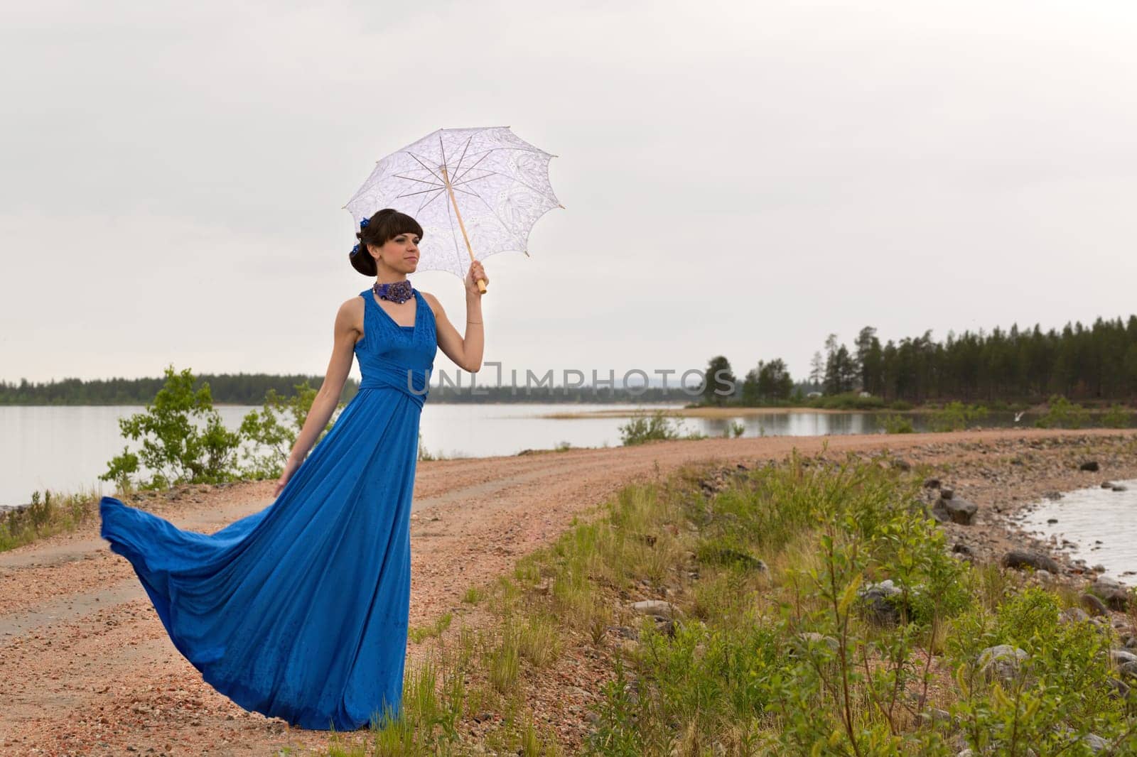 A girl tries to keep a umbrella which pulls out a wind from her hands.