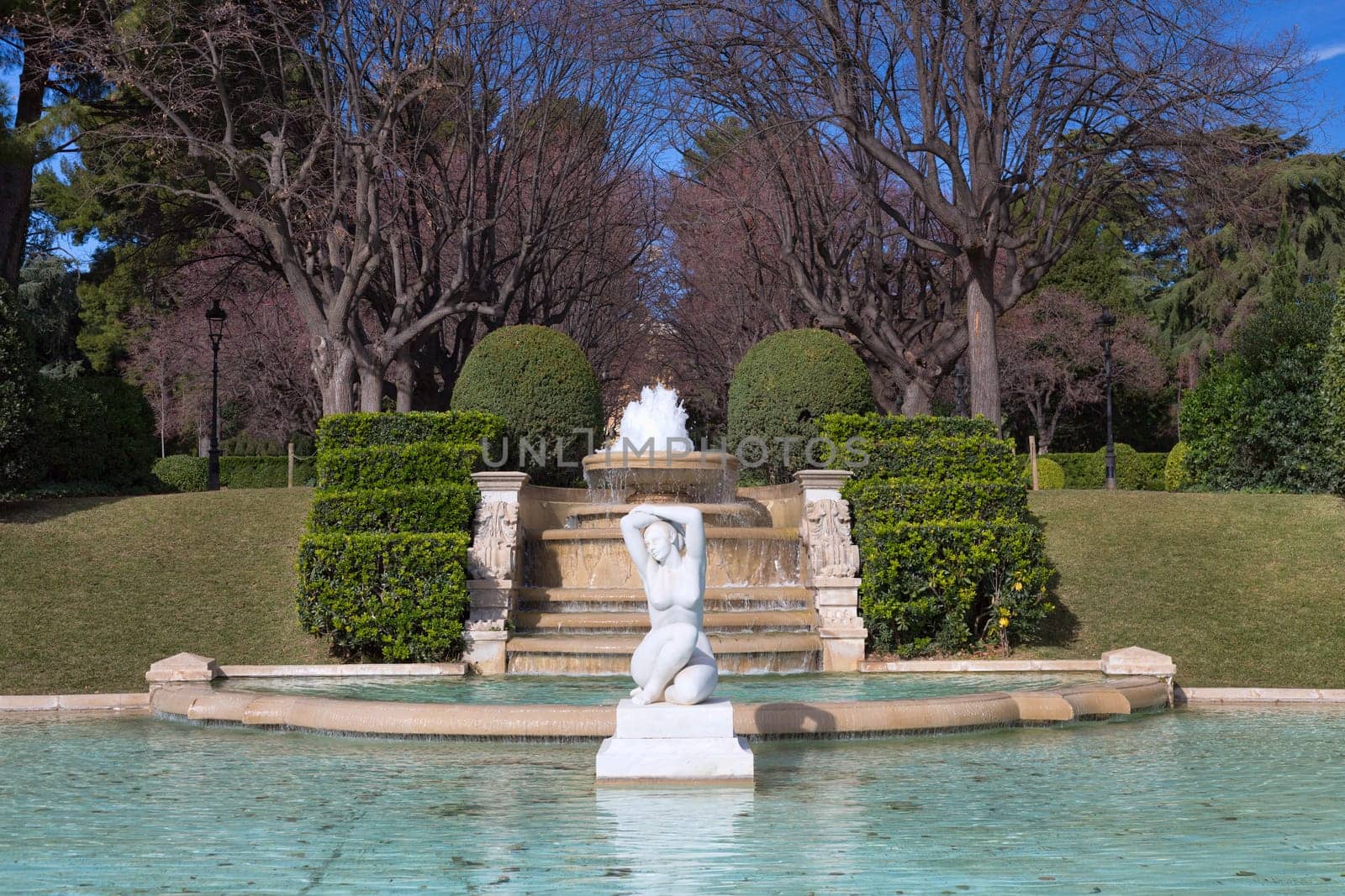 Fountain in the park on a background of the fence.