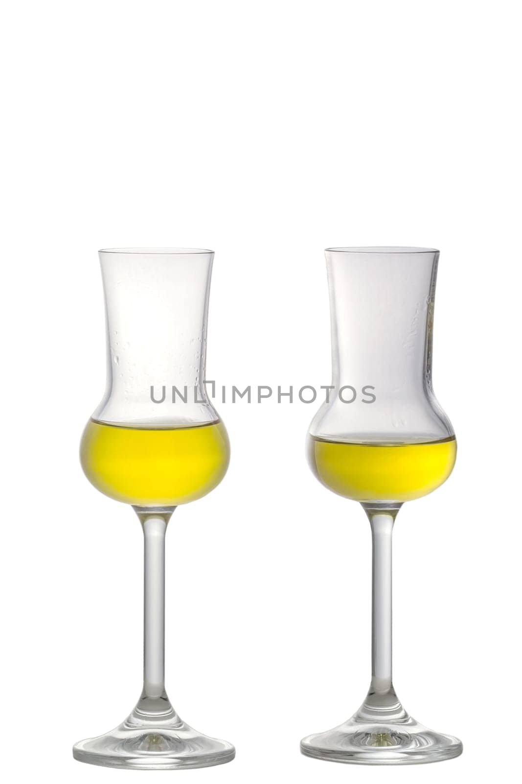 Two filled Grappa Glasses standing upright isolated on white