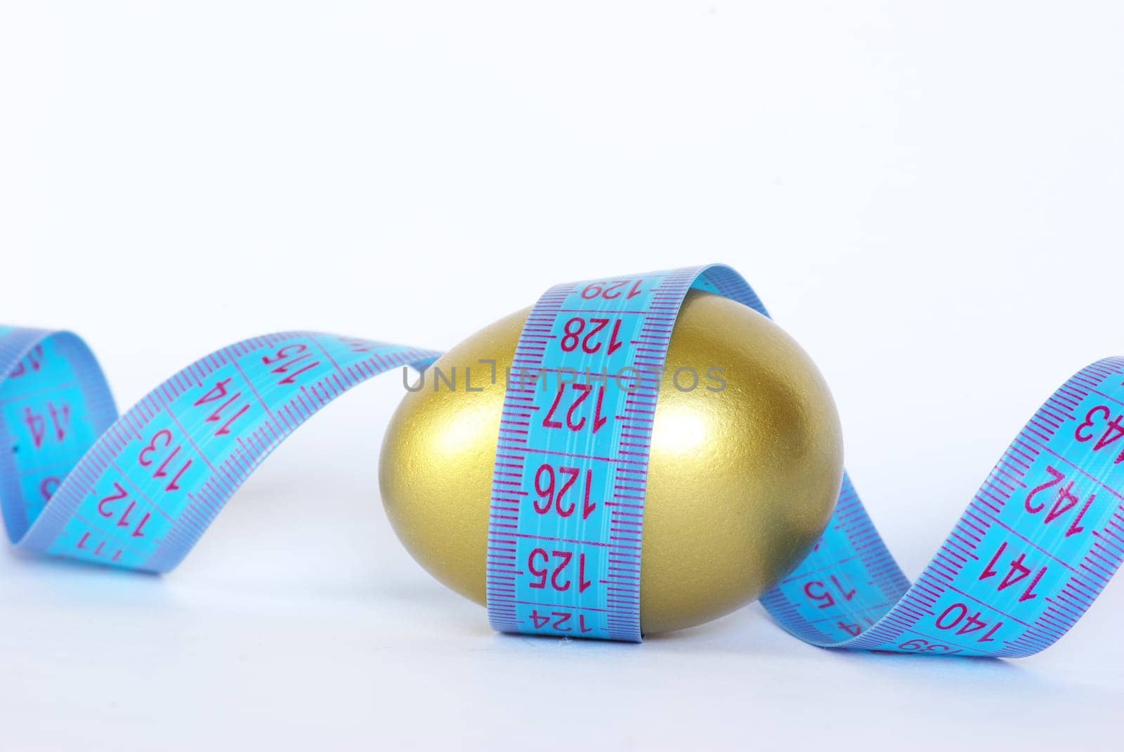 gold egg with measuring tape  around