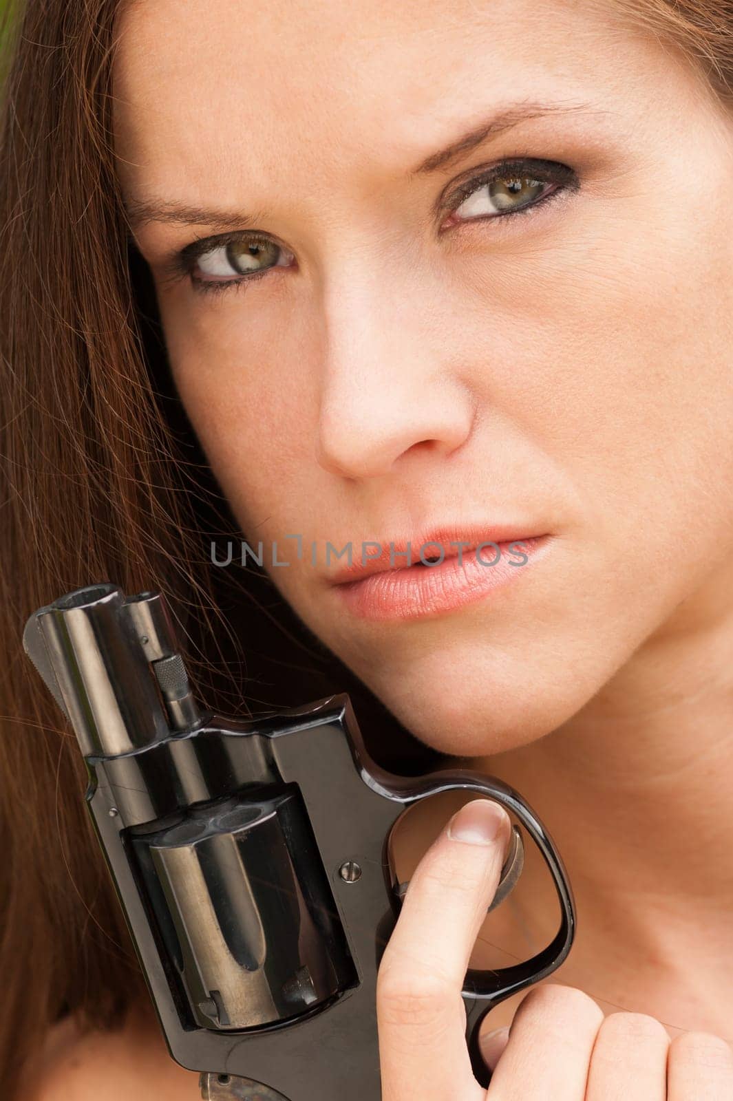 Woman holds revolver up to her face during a range session