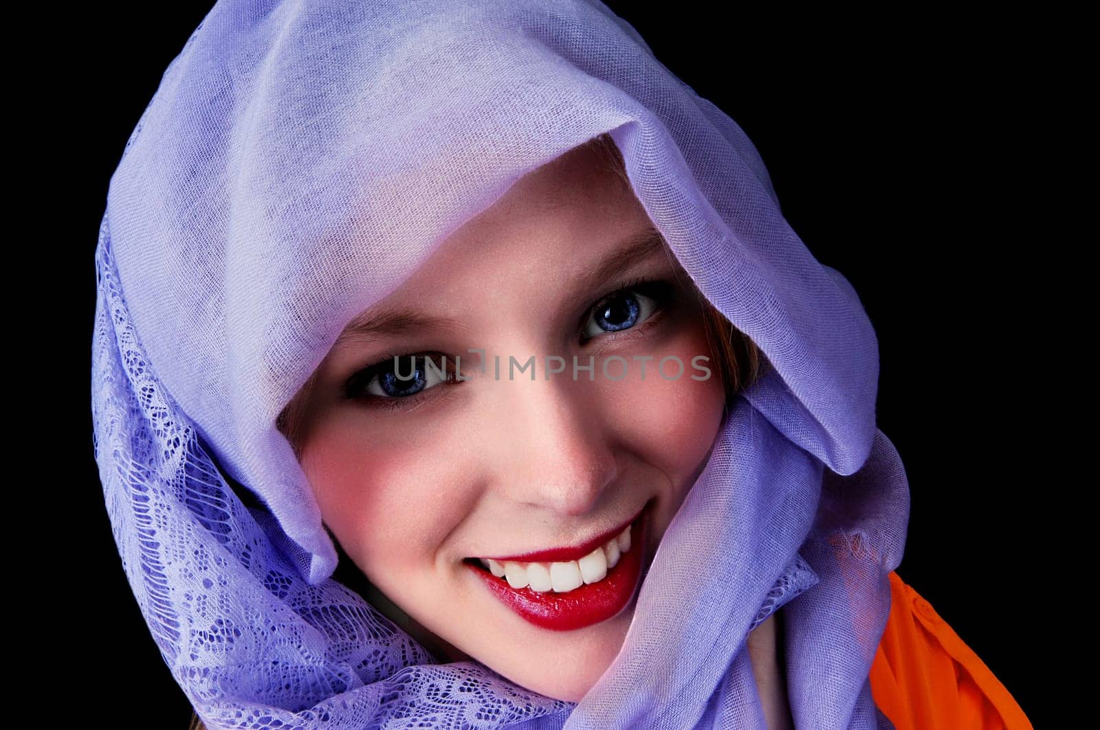 A beautiful young woman with blue eye's and a blue scarf around her.head, isolated for black background..
