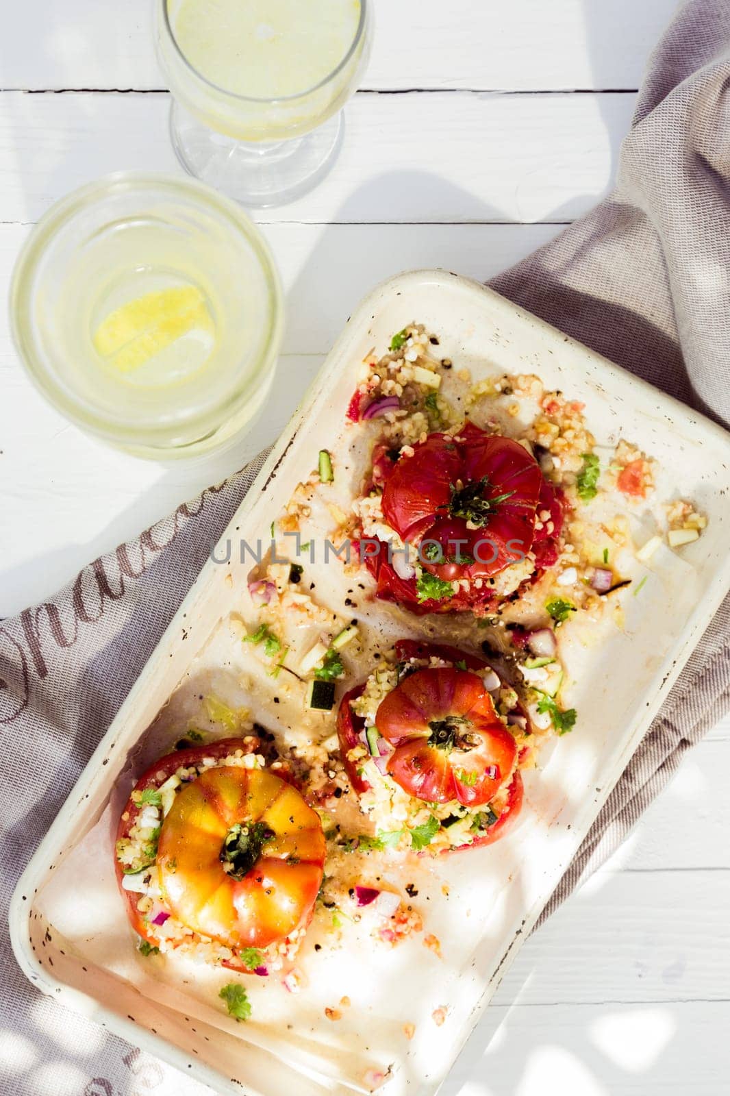 Stuffed ripe fresh tomatoes with cereal, rice onion and herbs filled to overflowing and served on a platter