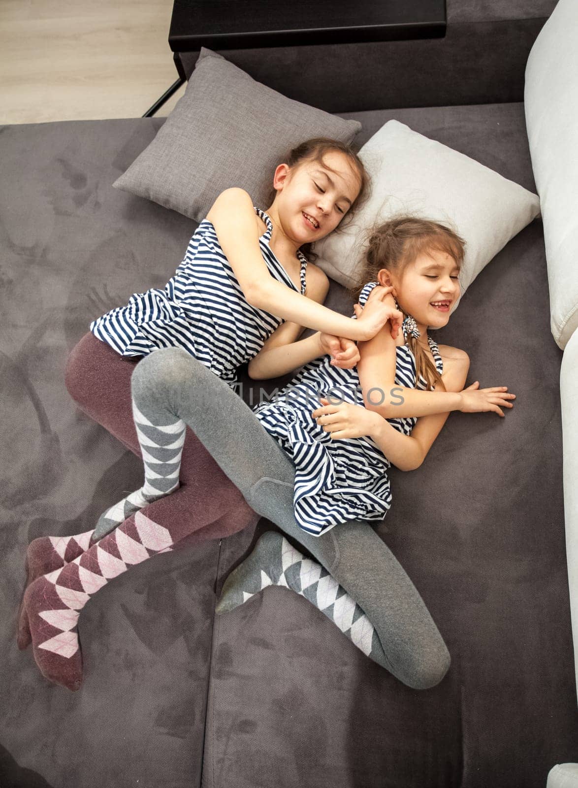 Two young sisters fighting on bed