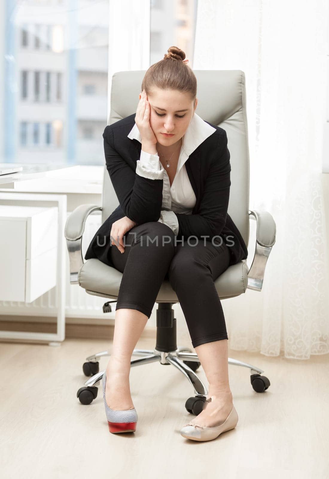 Young businesswoman choosing between comfortable and beautiful shoes