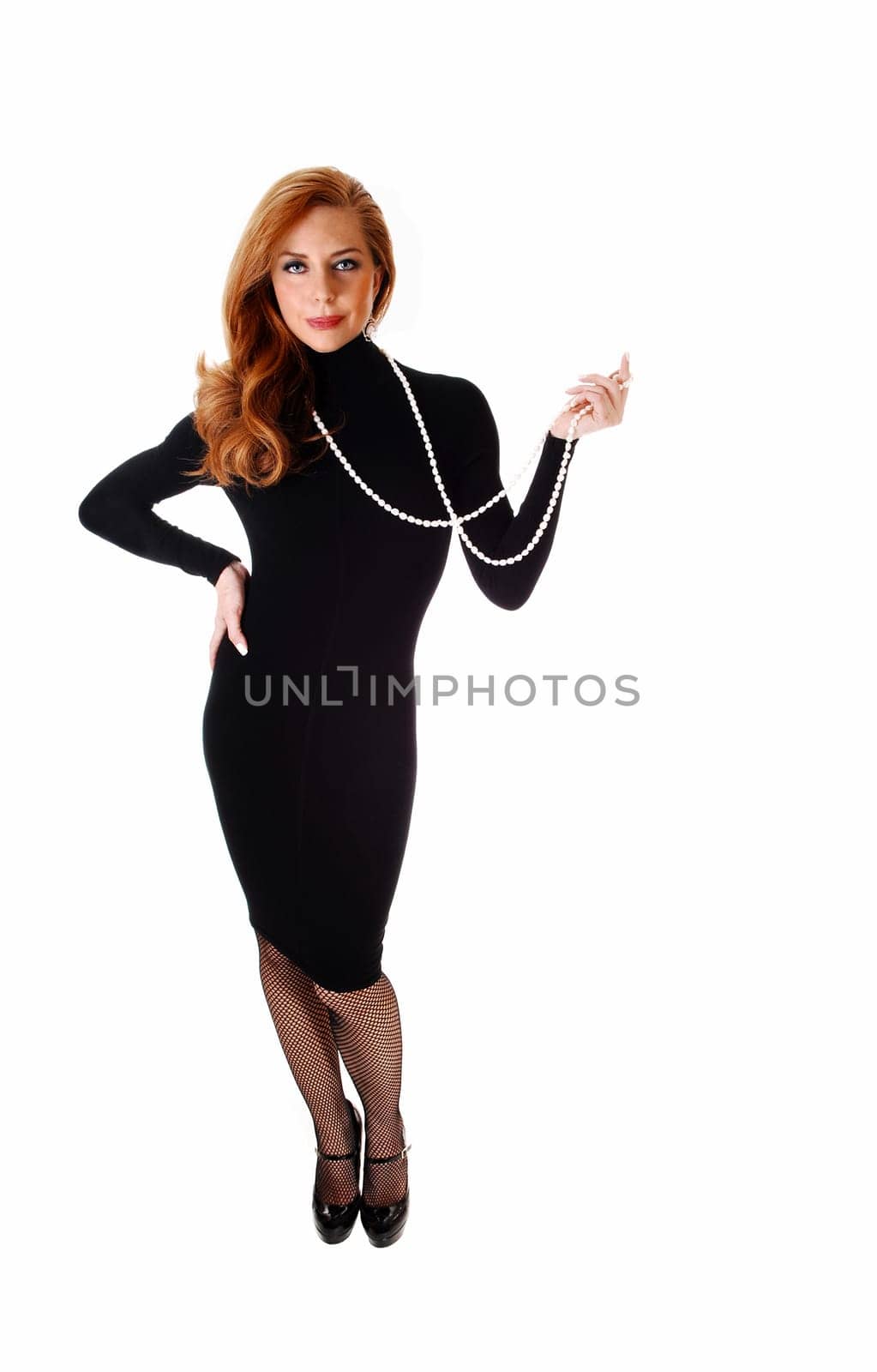 A middle aged woman standing in a black dress isolated for.white background..