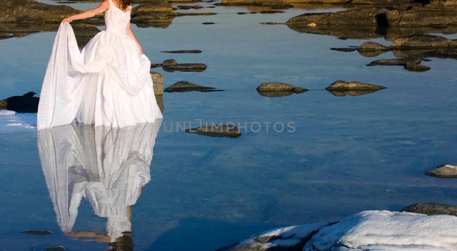 Vintage photo of beautiful bride standing on a cliff on the sea
