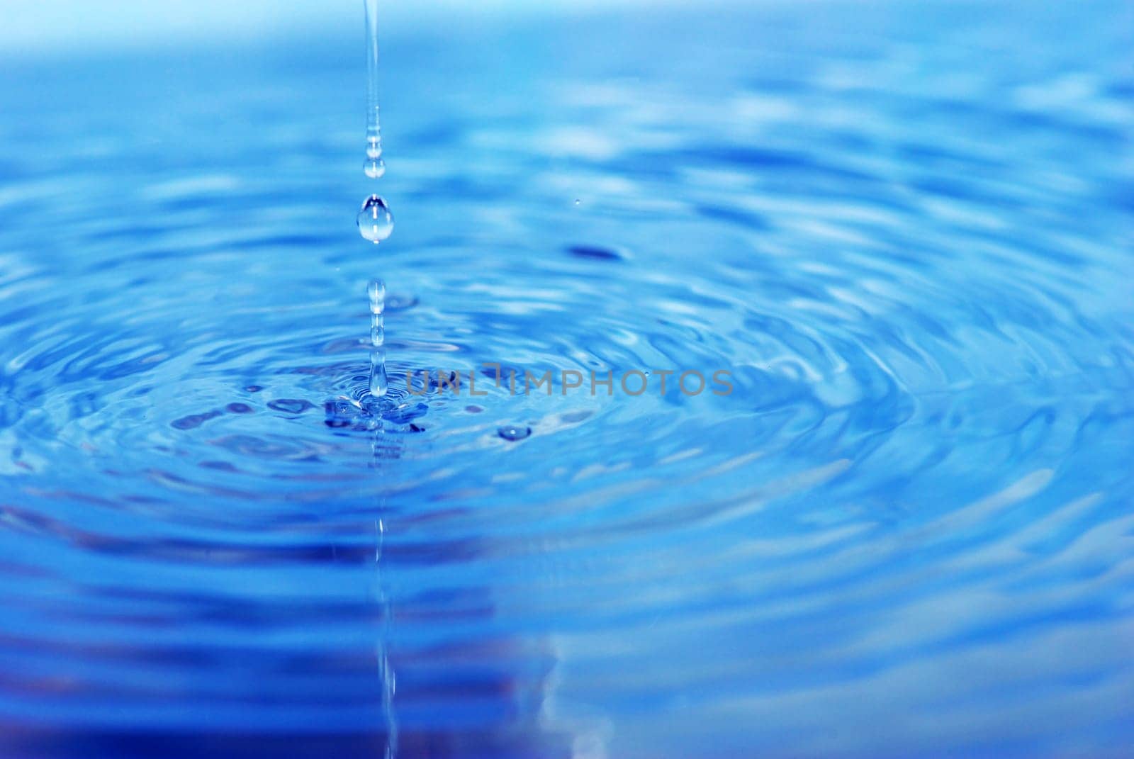 The round transparent drop of water falls downward