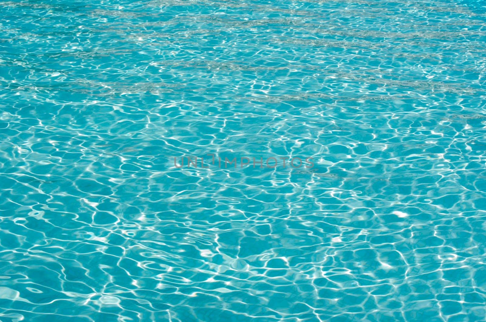 Blue pool water with sun reflections