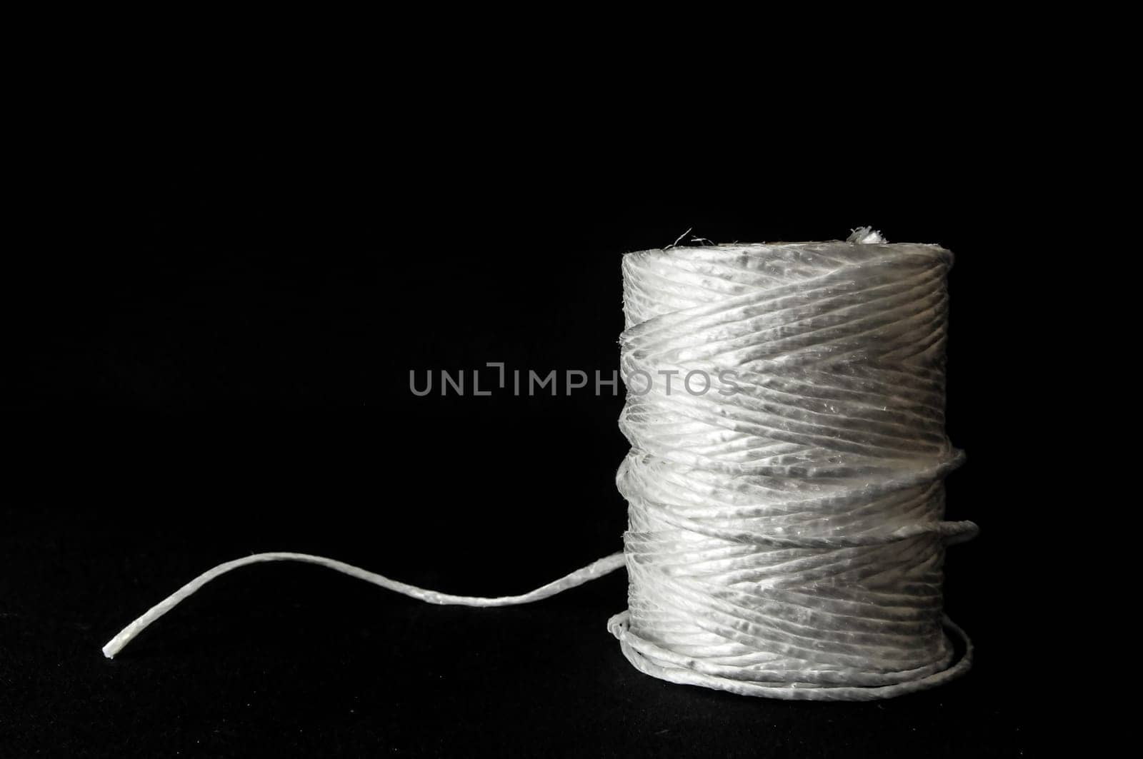Roll of White Twine on a Black Background