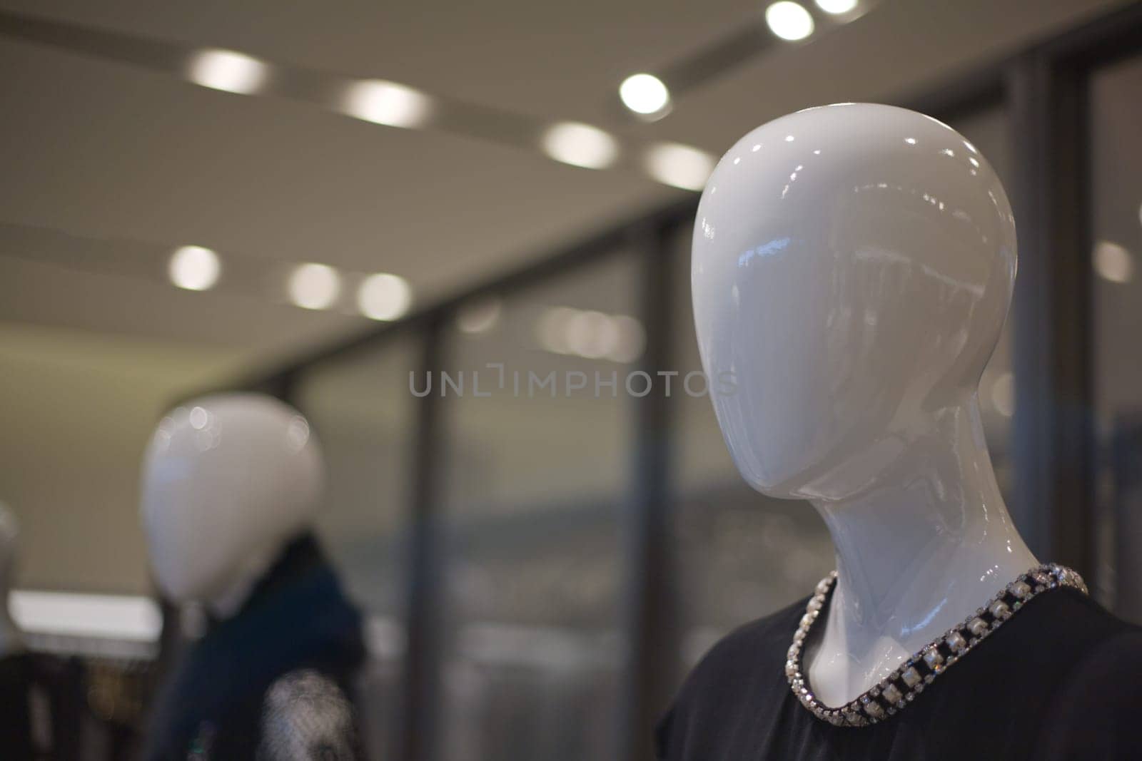 Boutique with mannequins without face in fashionable dresses