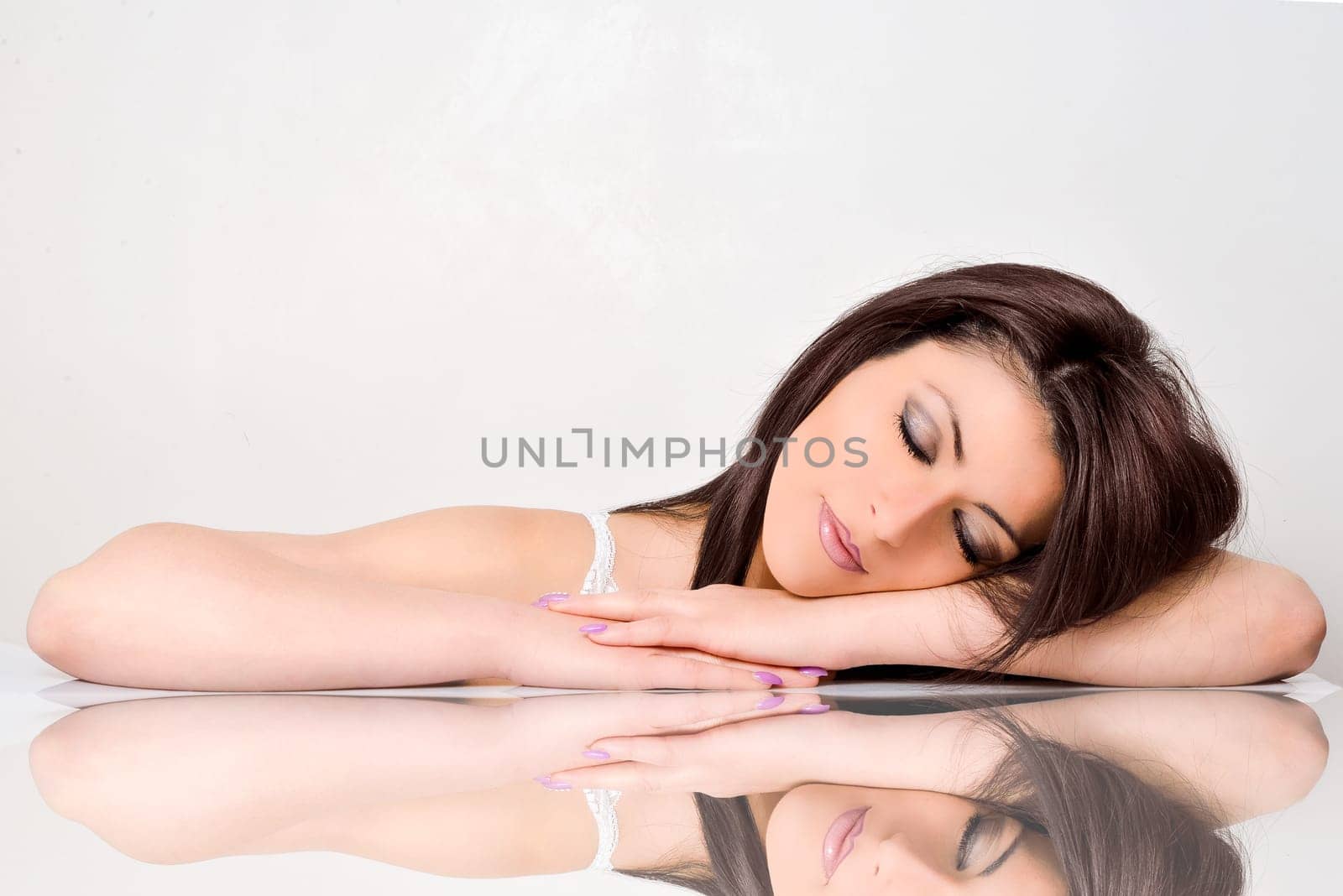 Beautiful face skincare beauty woman lying down with mirror reflection isolated on white background