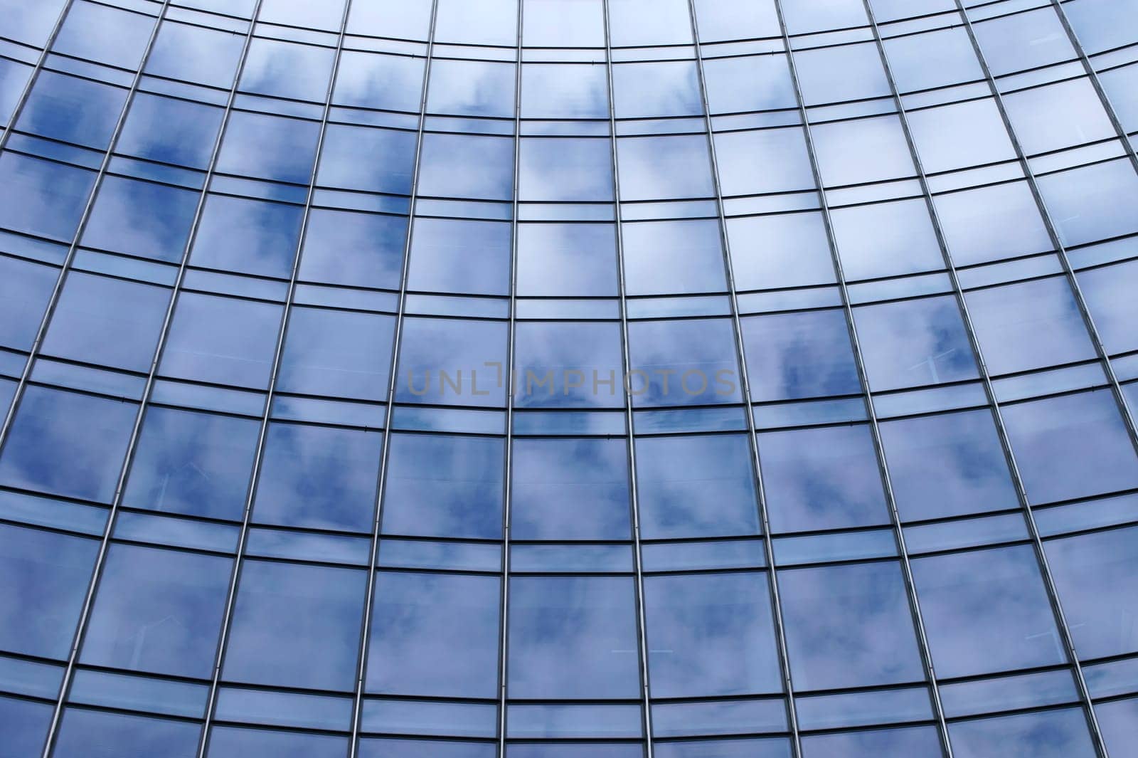 The photograph of cloud reflections in the windows of a high-rise facade.