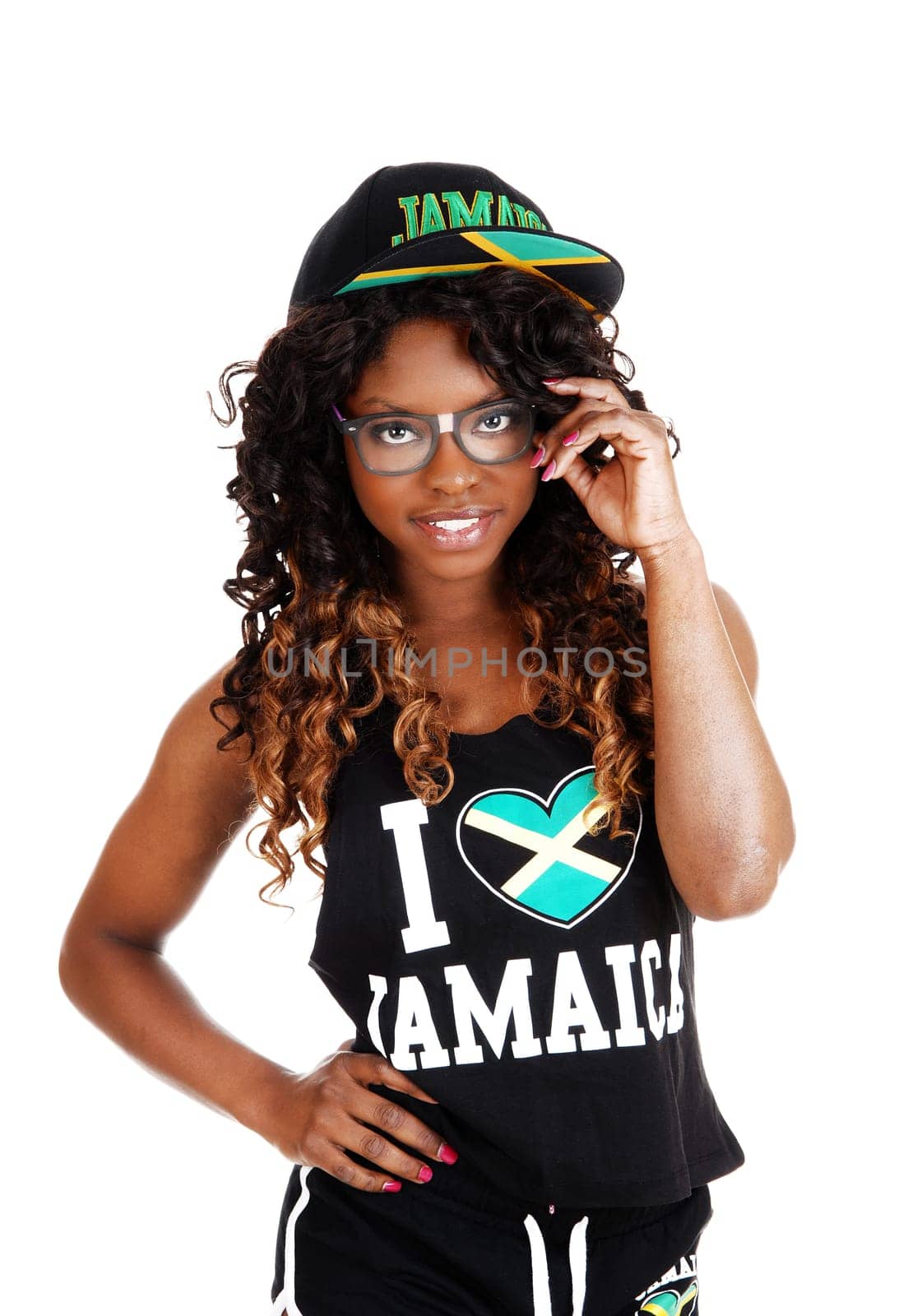 A pretty Jamaican woman in exercise outfit and a cap on her long.black and brown hair standing isolated for white background..