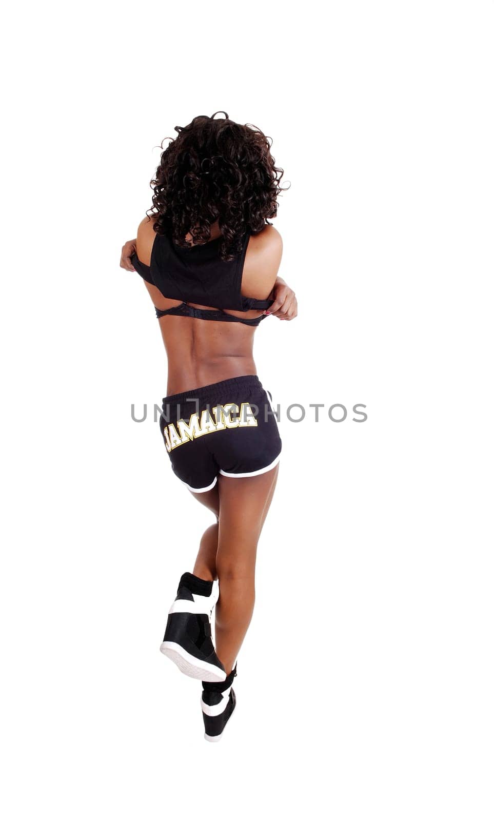 A pretty Jamaican woman in exercise outfit with her long.black and brown hair standing from the back, isolated for white background..