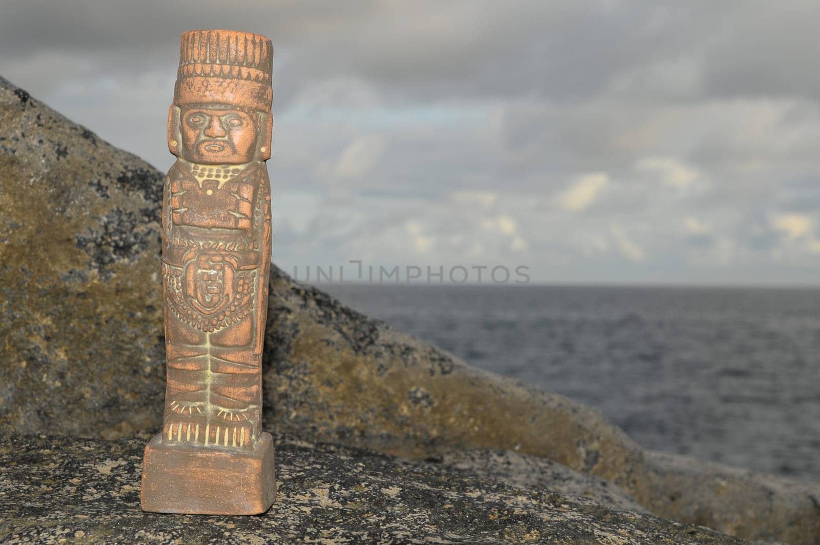 Ancient Maya Statue on the Rocks near the Ocean