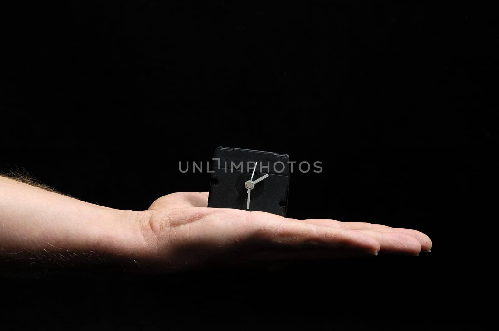 Clock And an Hand on a Black Background