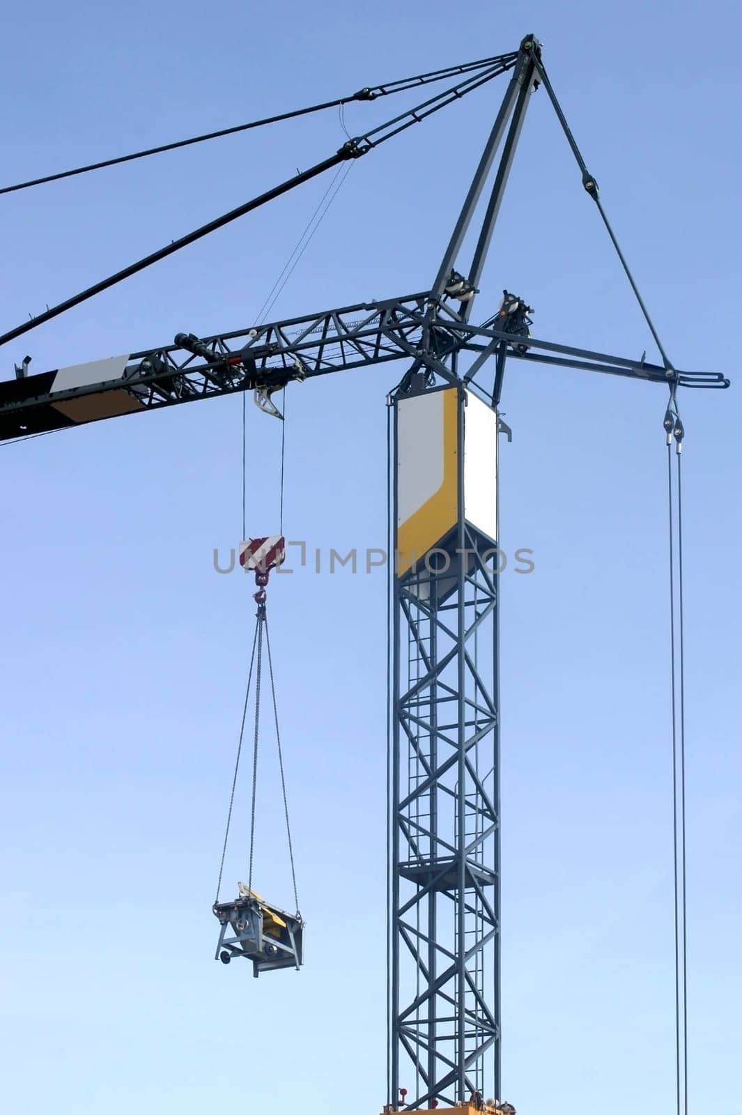The photograph of a lifting crane with a hanging load.