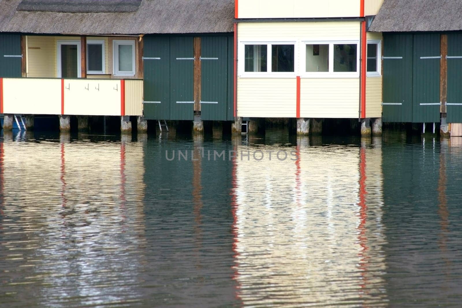 Photograph of houses with boat sheds on a lake.