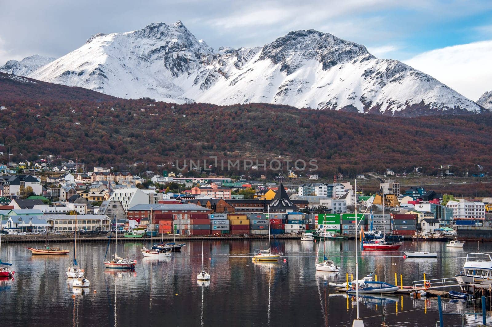 Reflection of the most southern city of Argentina in serene morning water of the Beagle Channel..Ushuaia is the capital of the Argentine province of Tierra del Fuego. Ushuaia is located in a wide bay on the southern coast of the island of Tierra del Fuego, bounded on the north by the Martial mountain range and on the south by the Beagle Channel.