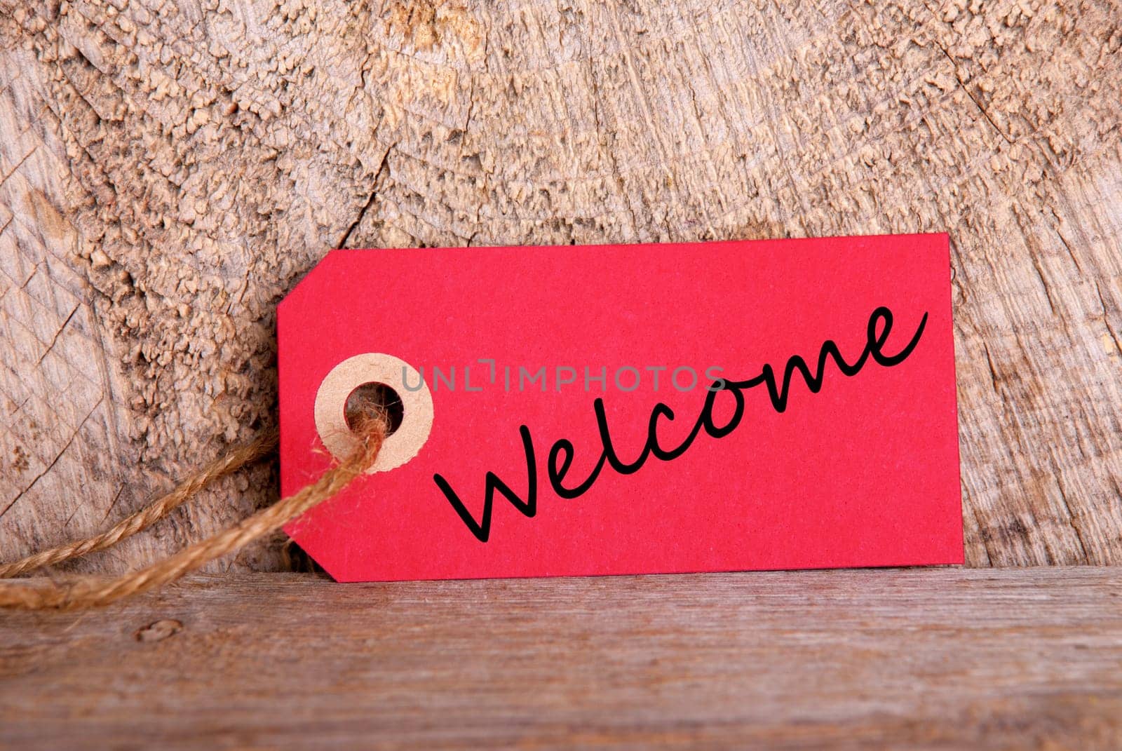 A Red Tag with the Word Welcome on Wood