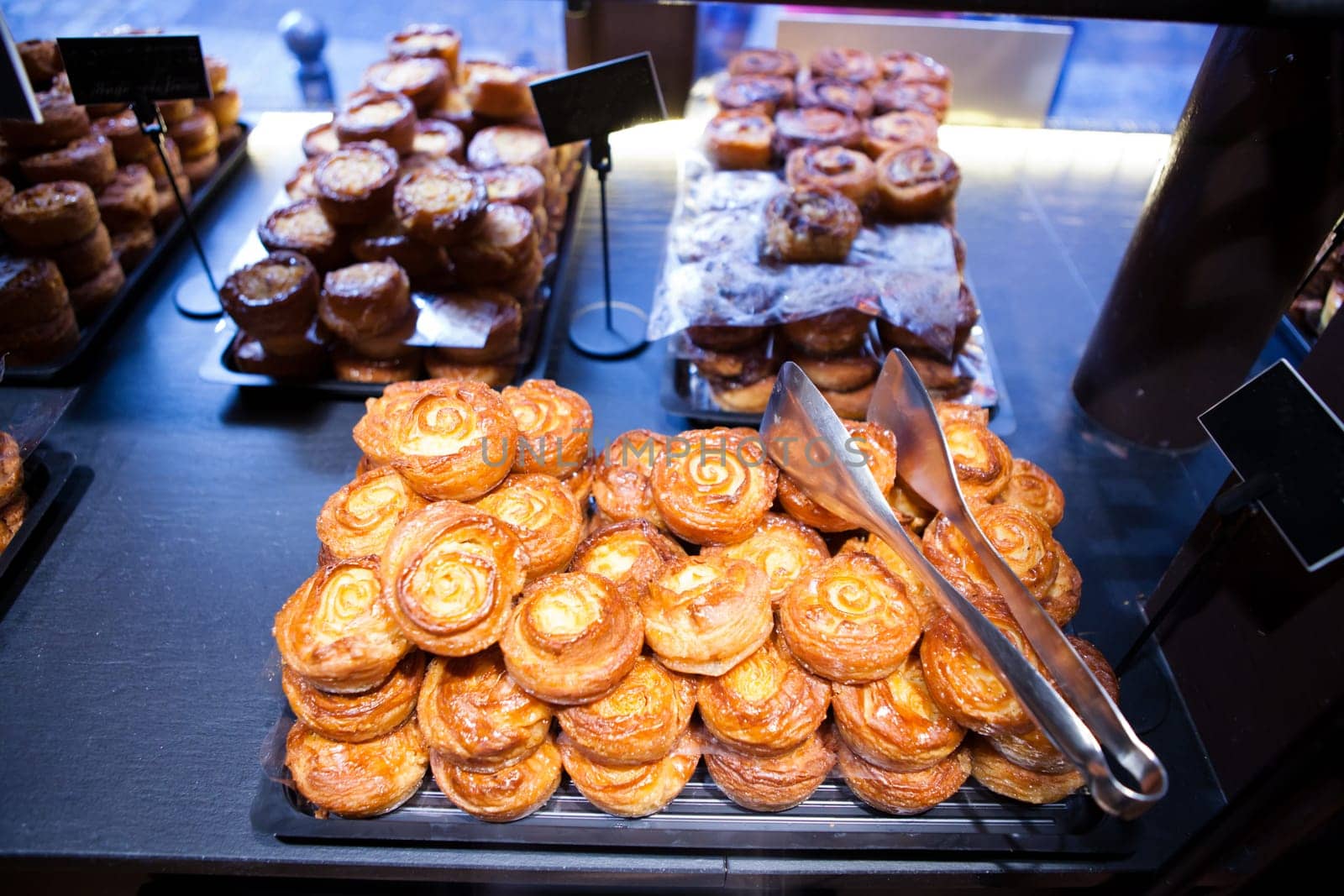Closeup of mix of various sweet buns on display trays at cafe