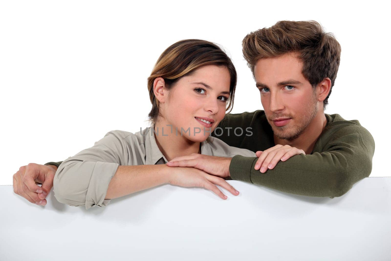 Couple leaning against a blank poster