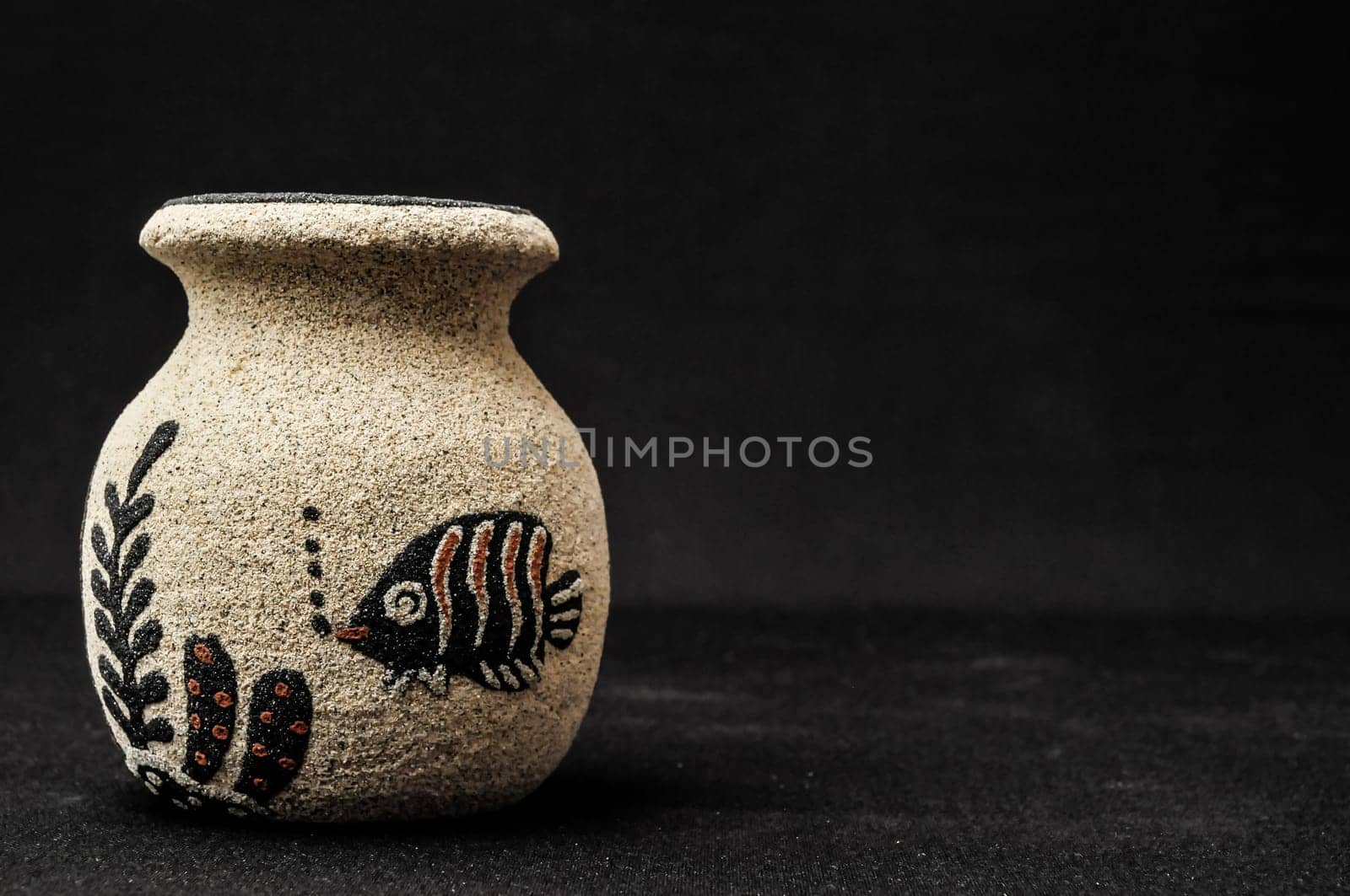 Colorful designed clay vase over a Black background