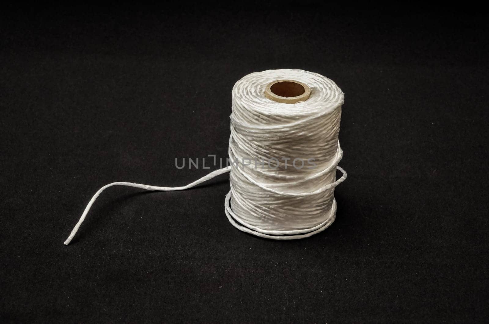 Roll of White Twine on a Black Background