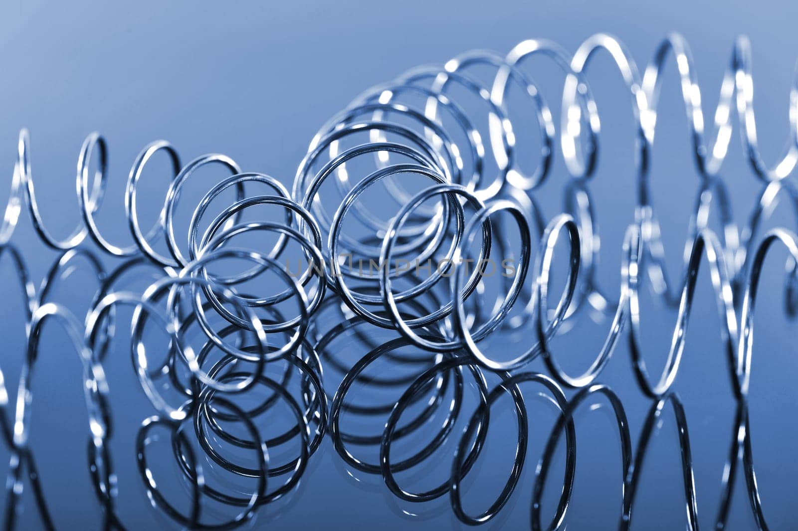 two interlocking chrome spirals bent on a blue background