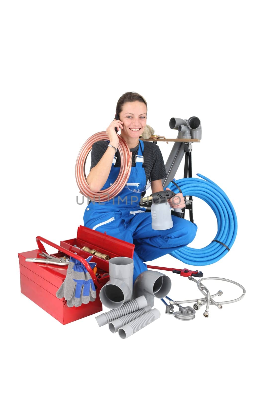 Female labourer speaking on mobile telephone surrounded by equipment
