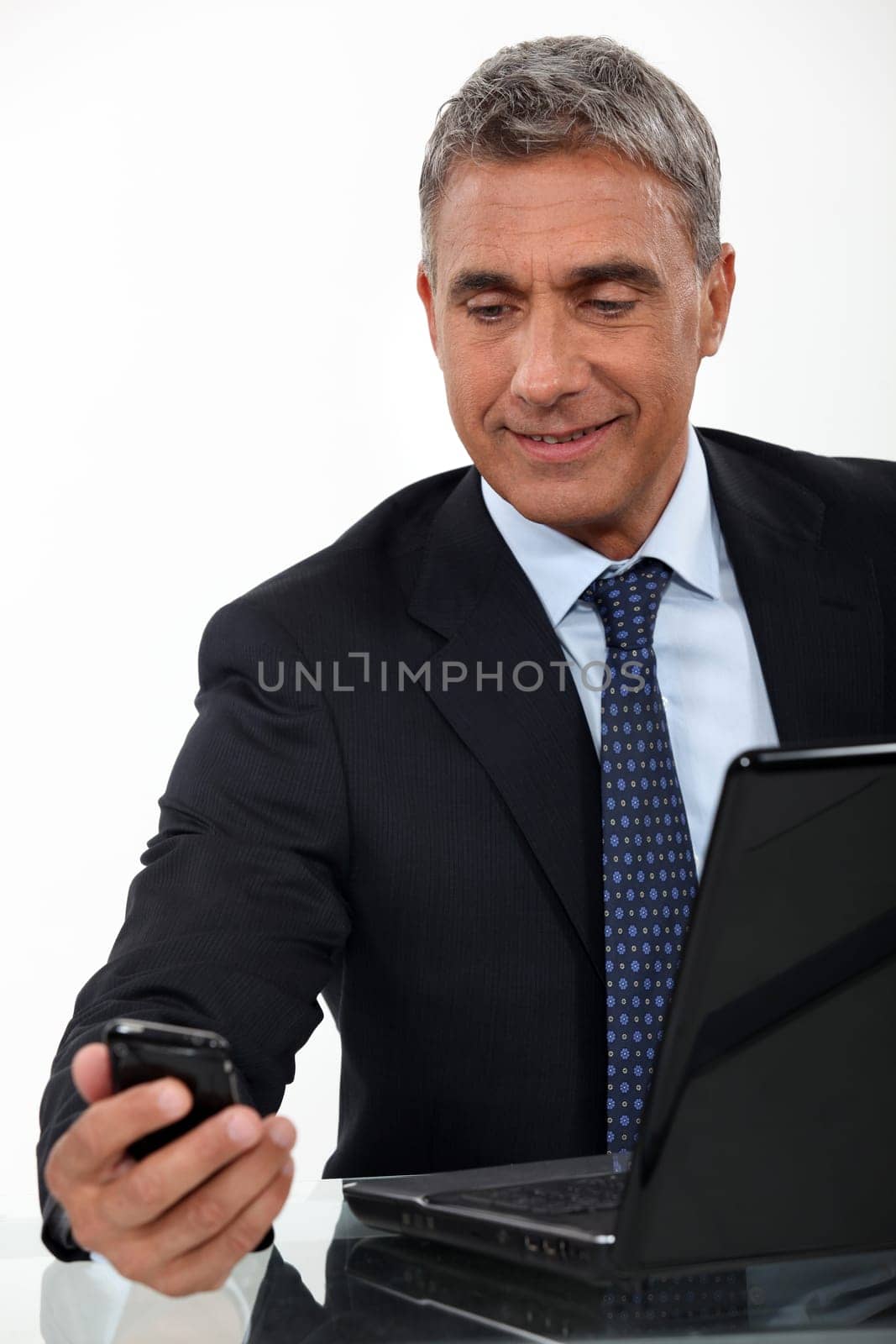 Mature businessman with a laptop and cellphone