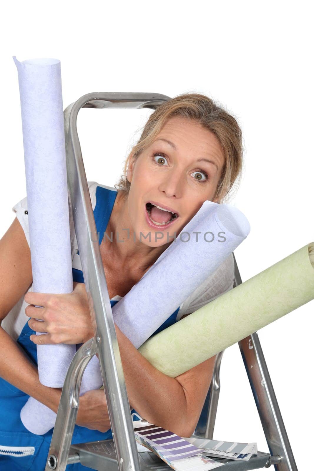 Happy woman with rolls of wallpaper