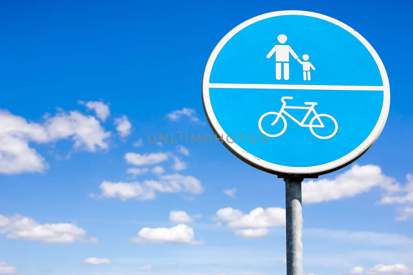 Bicycle and pedestrian shared route sign on the sky background