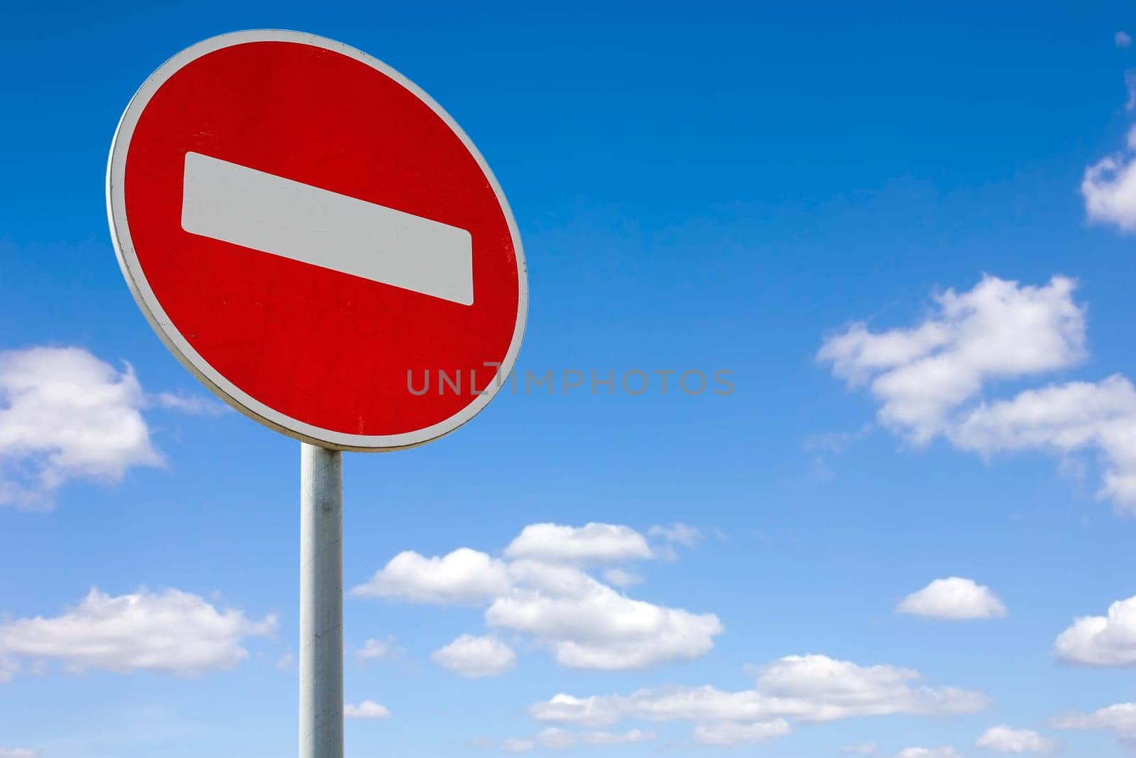 Roadside red stop sign on a cloudy background