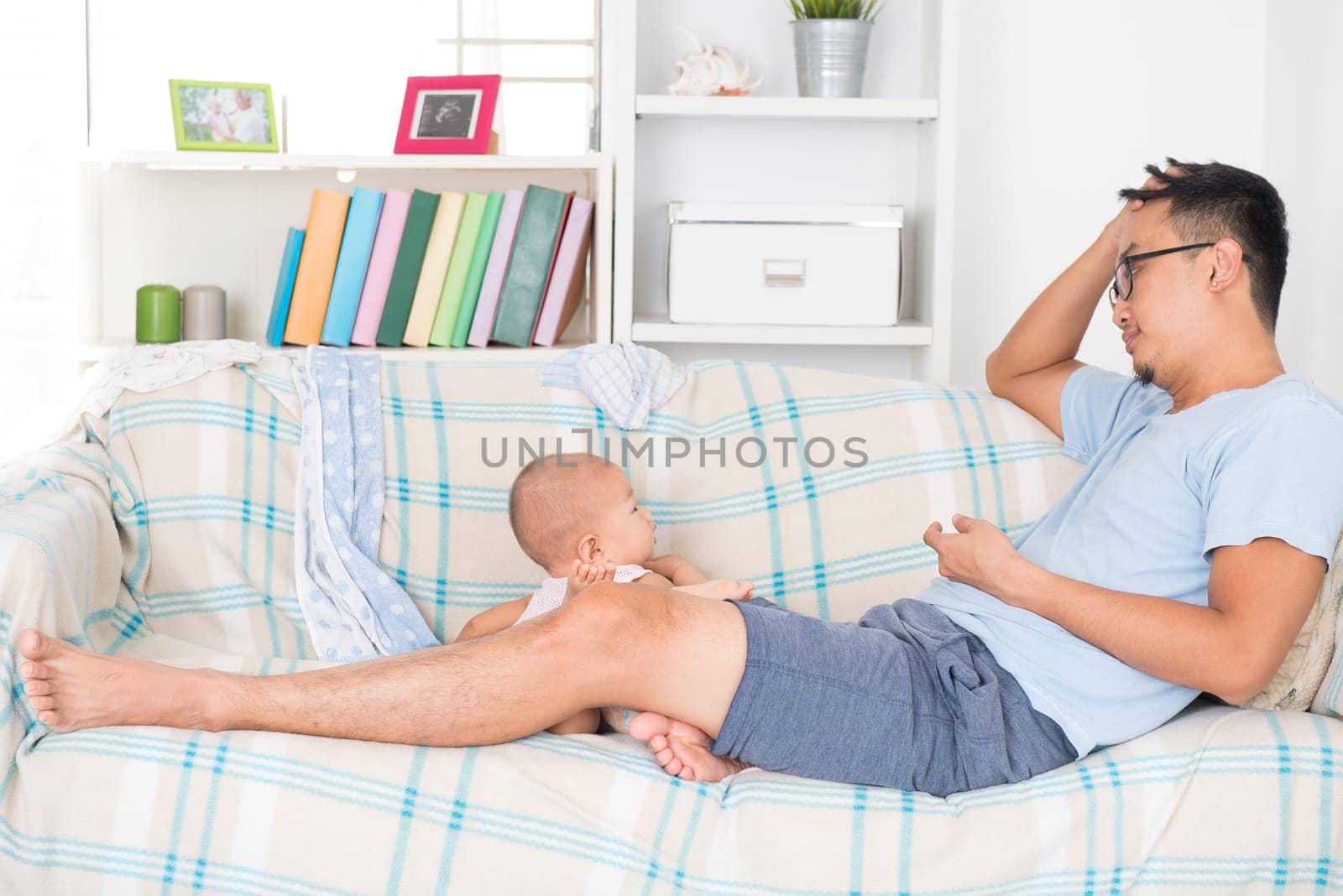 Tired daddy and naughty baby boy. Asian family lifestyle at home.