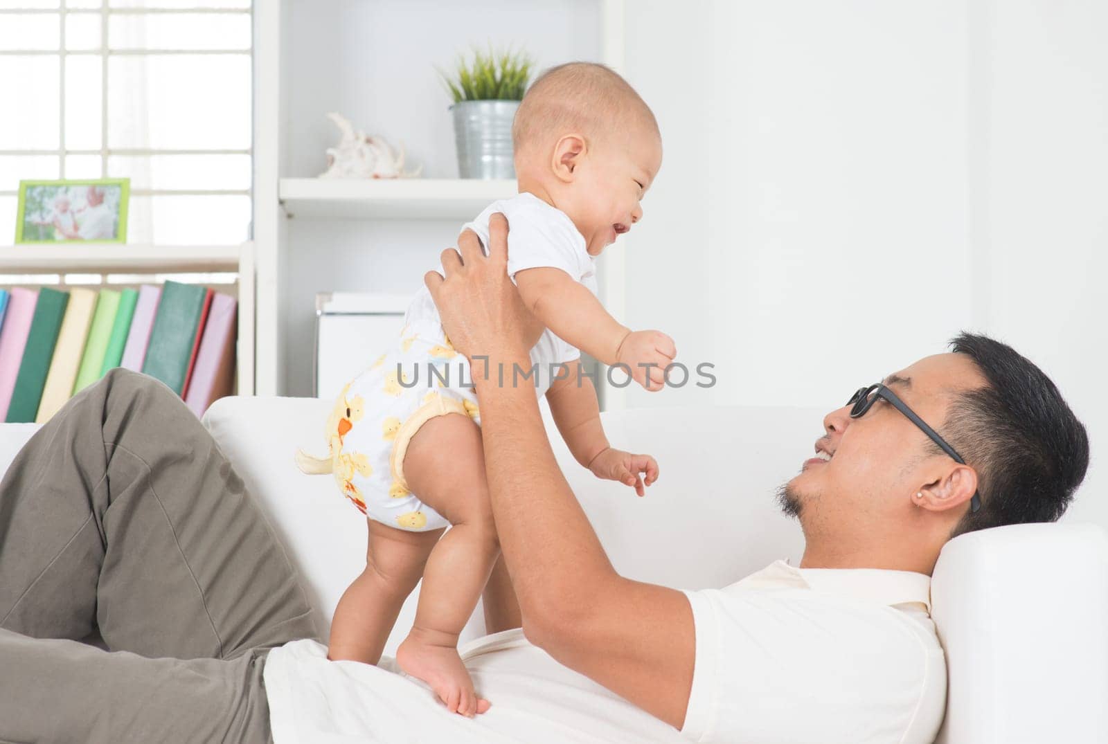 Asian family lifestyle at home. Father playing with baby boy.
