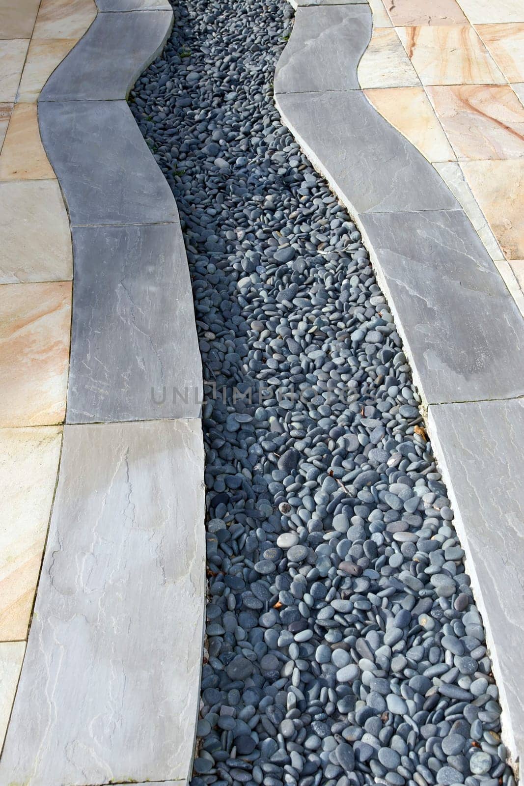 a garden patio design with slabs and pebbles