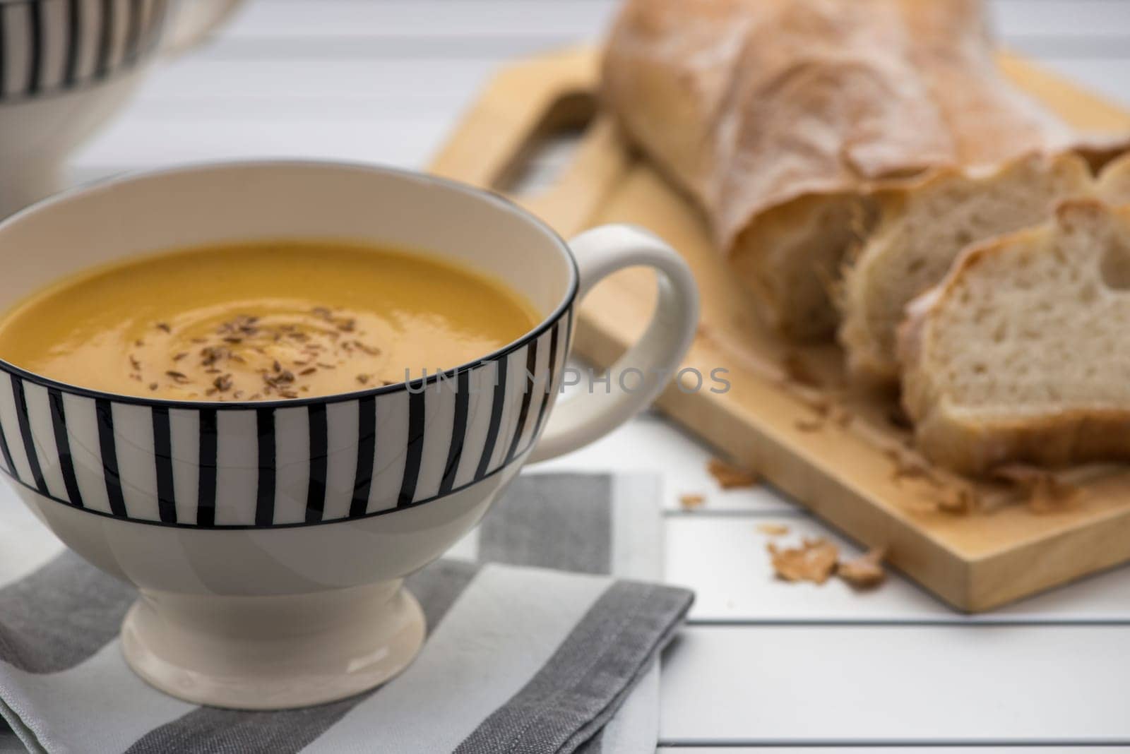 Retro styled mug full of Pumpkin soup with toasted cumin seeds on top