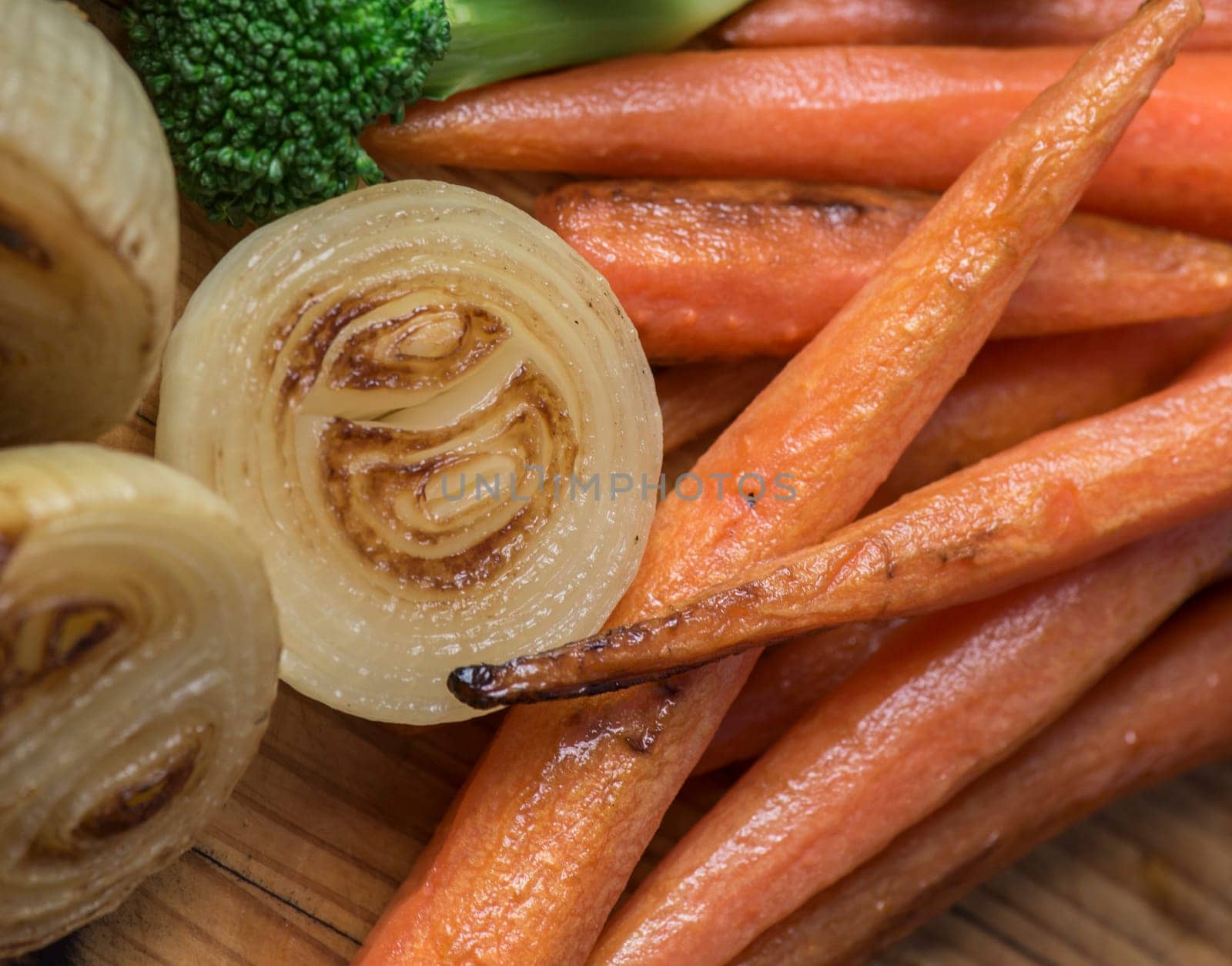 Perfectly roasted carrots and onions on a wooden platter