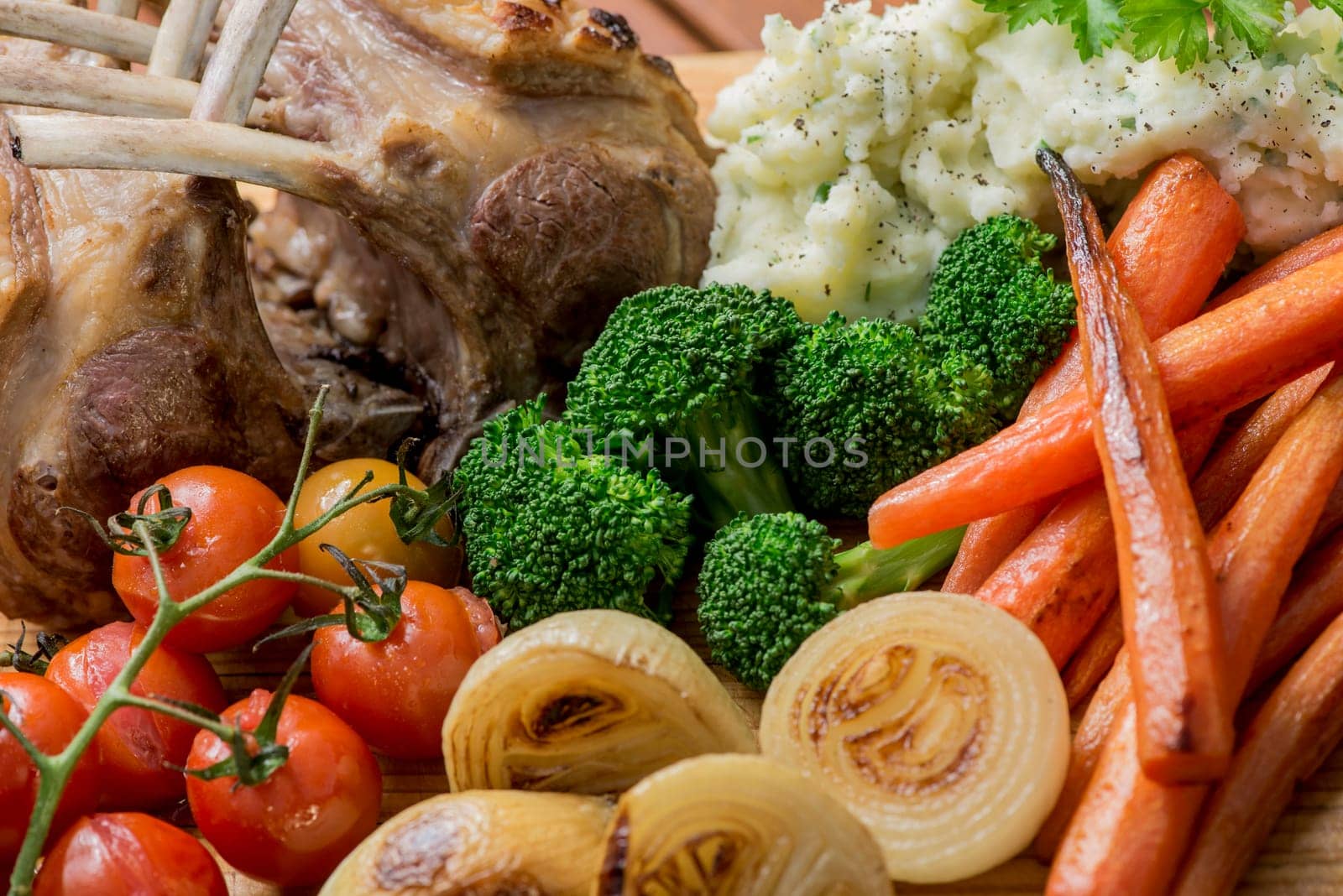 Roast Rack of Lamb with roasted mixed vegetables, onions, carrots, tomatoes, broccoli and mashed potato