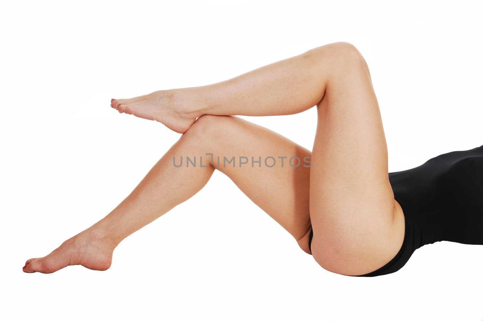 The body part of woman's legs in a black corset lying on her back on the .floor, isolated on white background..