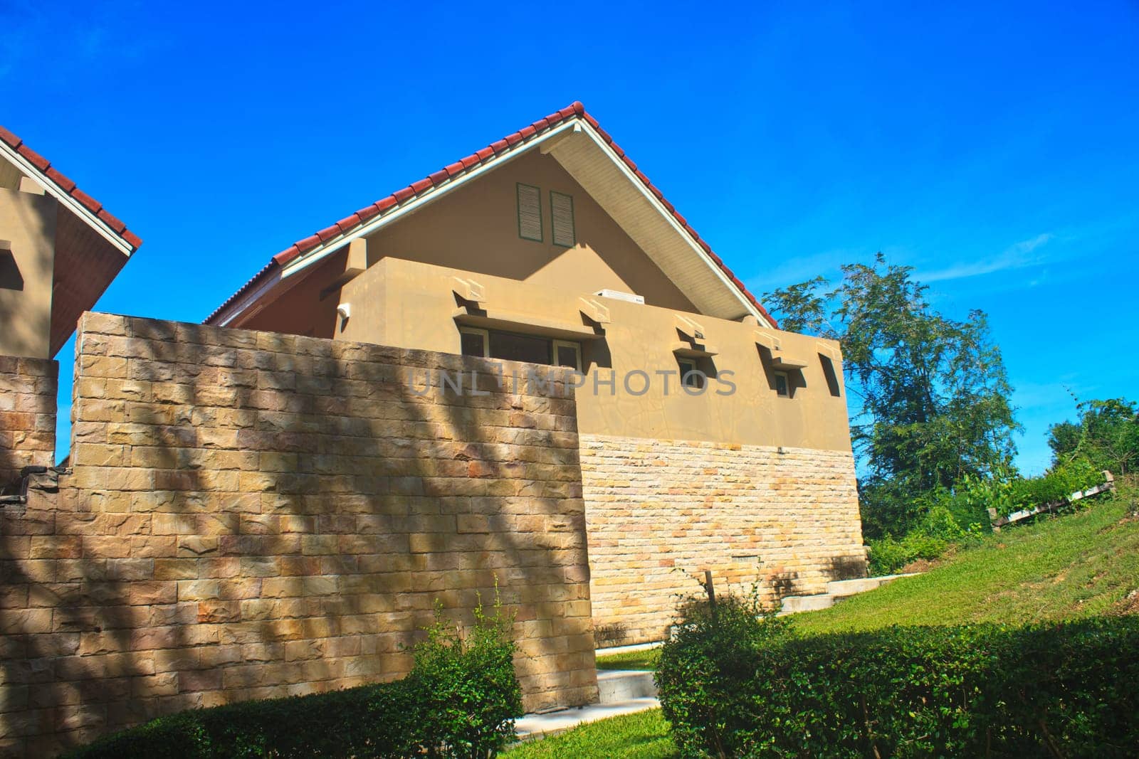 modern bricks house, patio with columns and garden