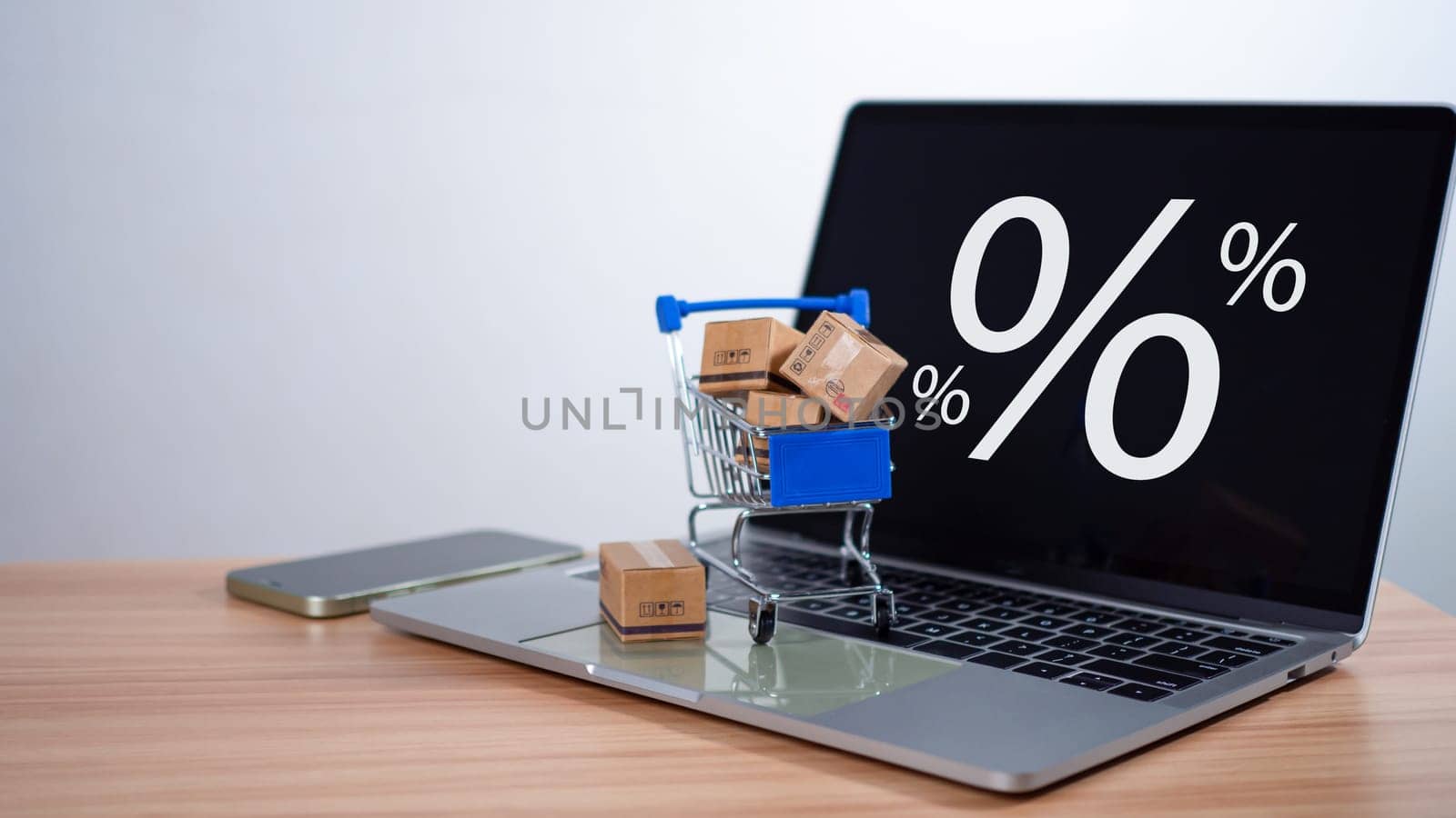 Sale percentage with shopping cart and boxes placed on computer keyboard. Online shopping concept, special price products, Special offers and promotions by Unimages2527