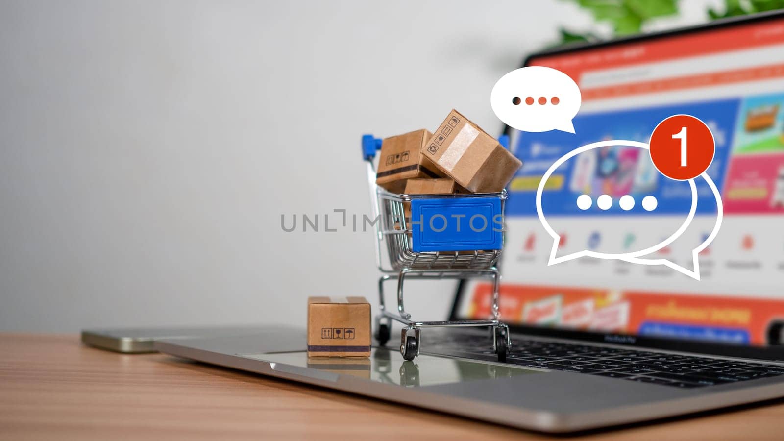 Shopping carts and product boxes Place on laptop computer showing online shopping concept, website, e-commerce, market platform, technology and online payment concept. by Unimages2527