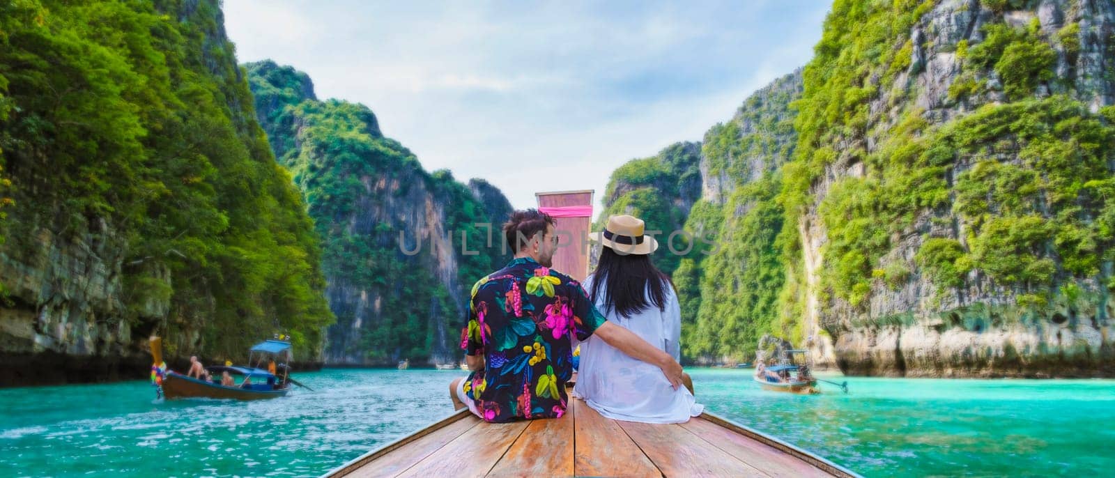 Thai women and Caucasian men in front of a Longtail boat at the lagoon of Koh Phi Phi Thailand. Pileh Lagoon Thailand Koh Phi Phi Krabi on a summer day